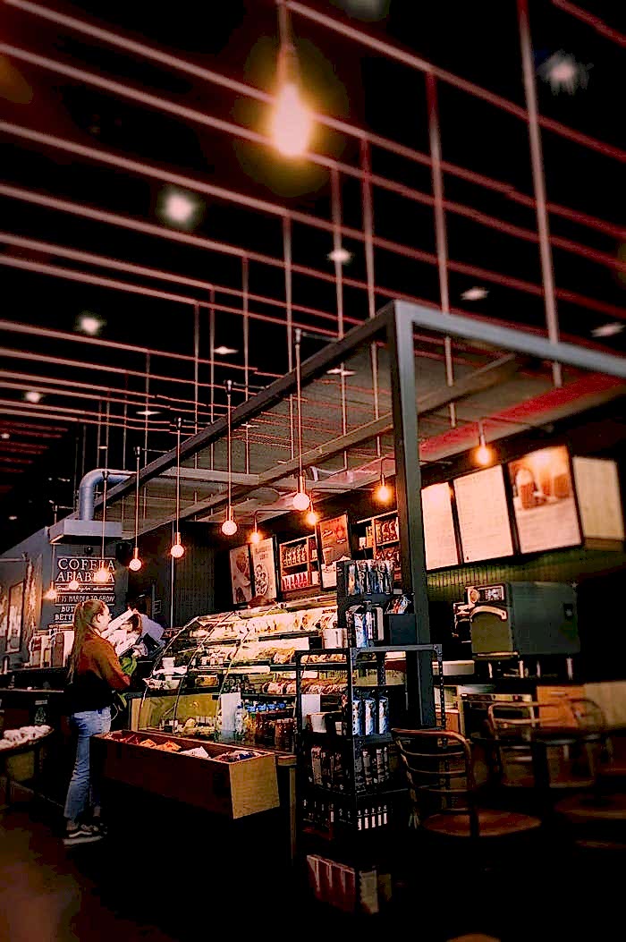 Warm and inviting café interior with modern lighting and seating. Perfect for a relaxing coffee break.